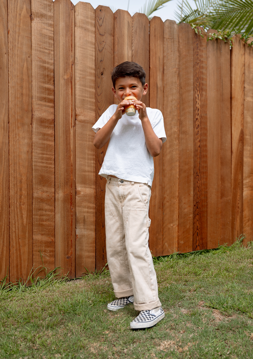 4oz babychino cup in toddler’s hands, toddler drinking outdoors